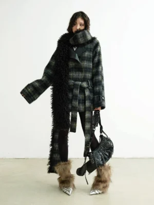 Side view of dark green plaid wrap coat showing double-breasted closure, matching waist belt, oversized collar, faux fur trim, and fringe detail