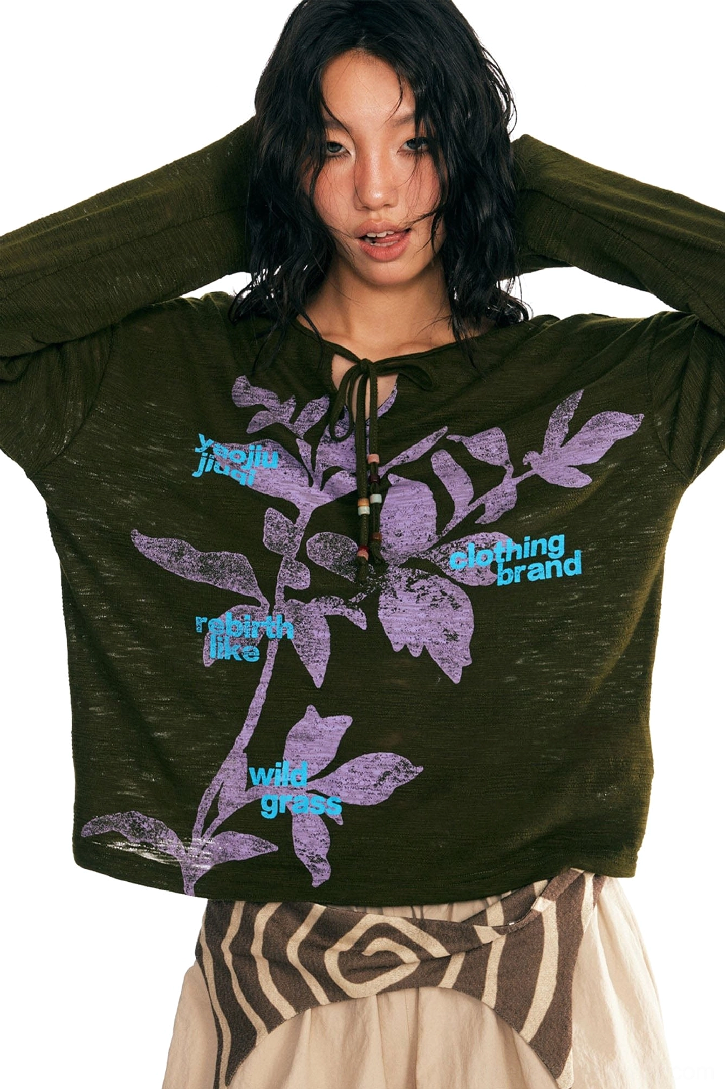 Close-up of dark green sesame leaf graphic tee showing slub texture beaded drawstring neckline and retro typography