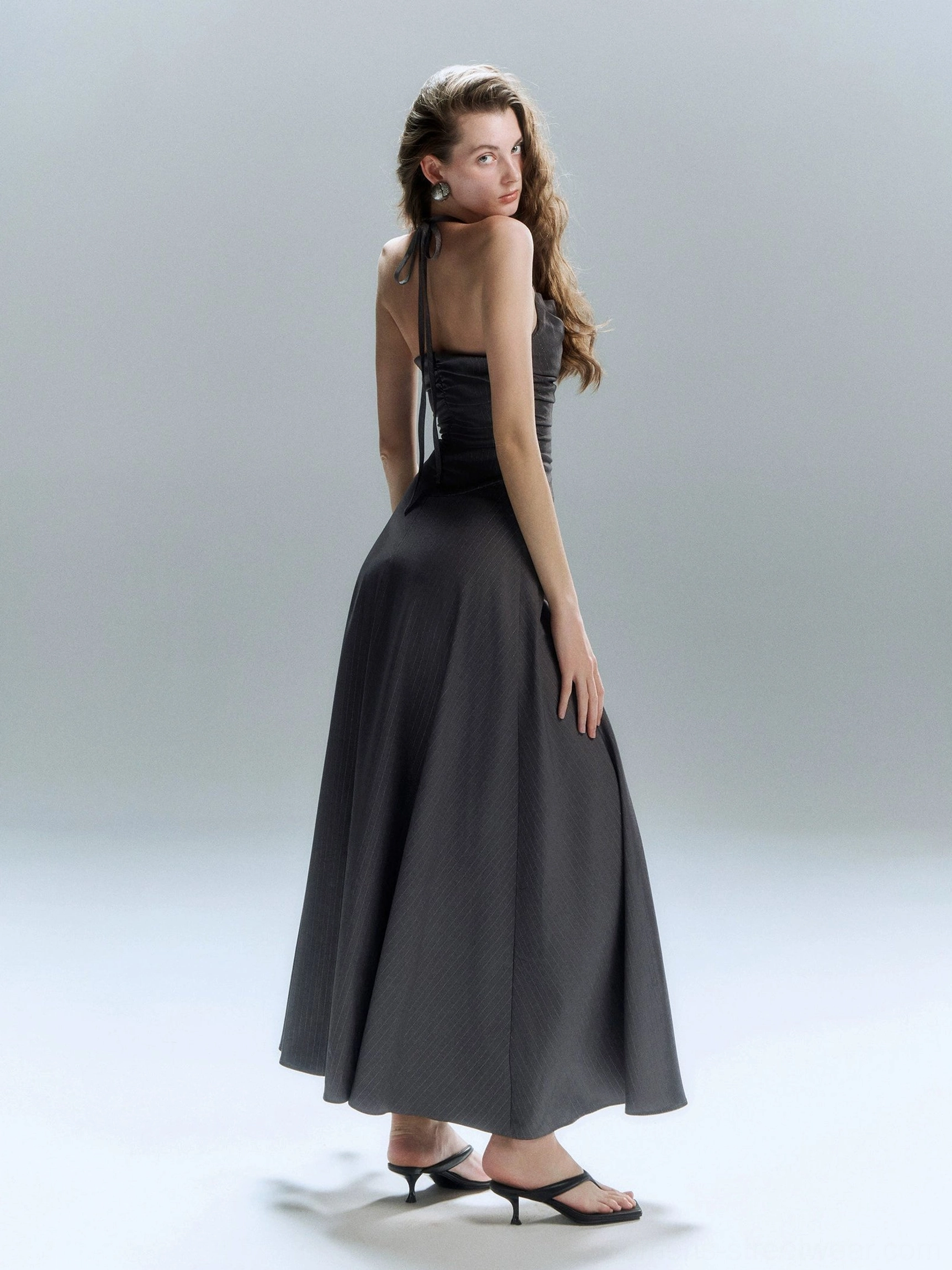 Dark grey floor length evening dress with fitted bodice high waist and sleek A line skirt shown from the back