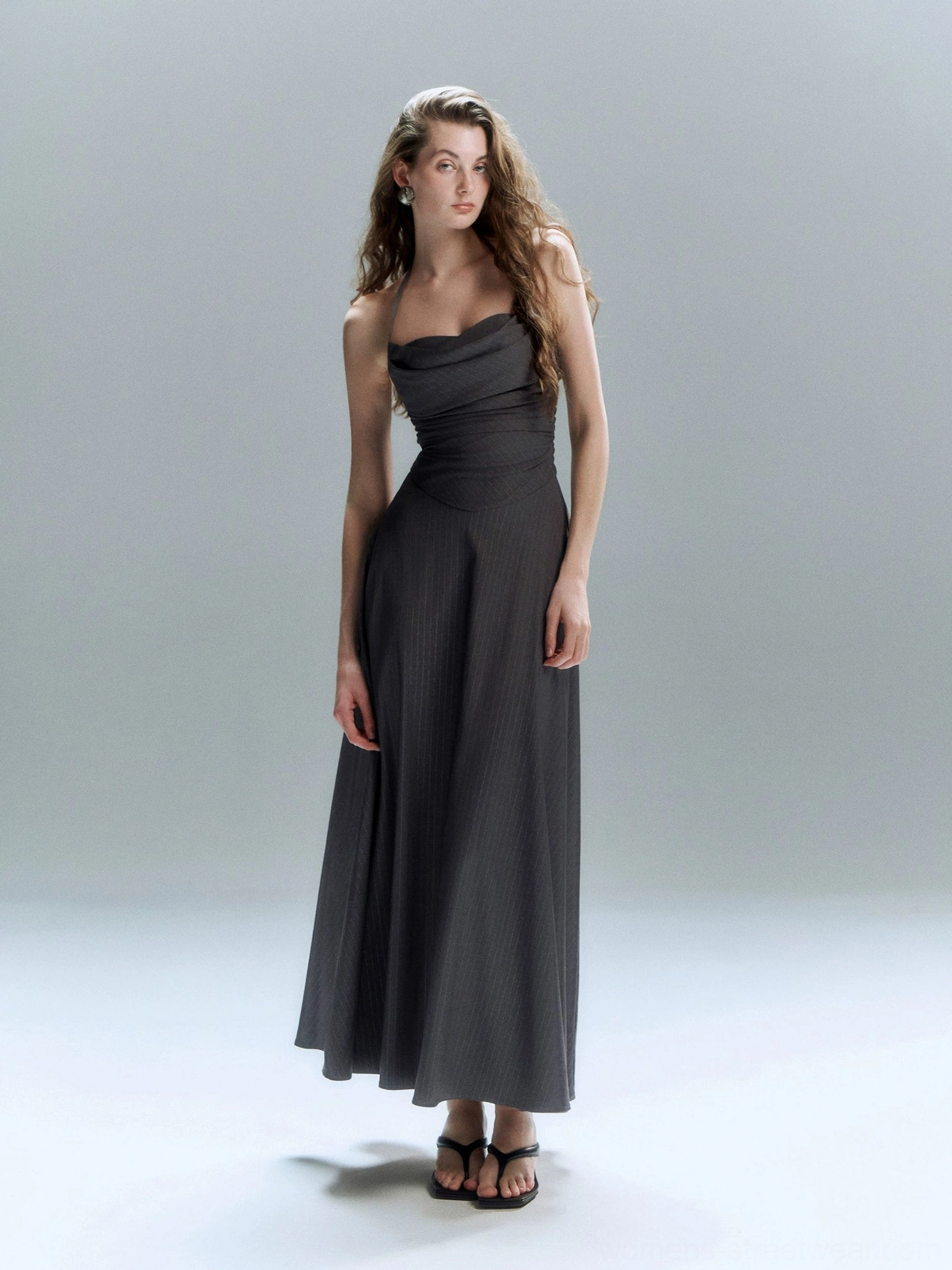 Dark grey floor length formal dress with ruched bodice flowing A line skirt and strapless neckline shown in a full body front studio view