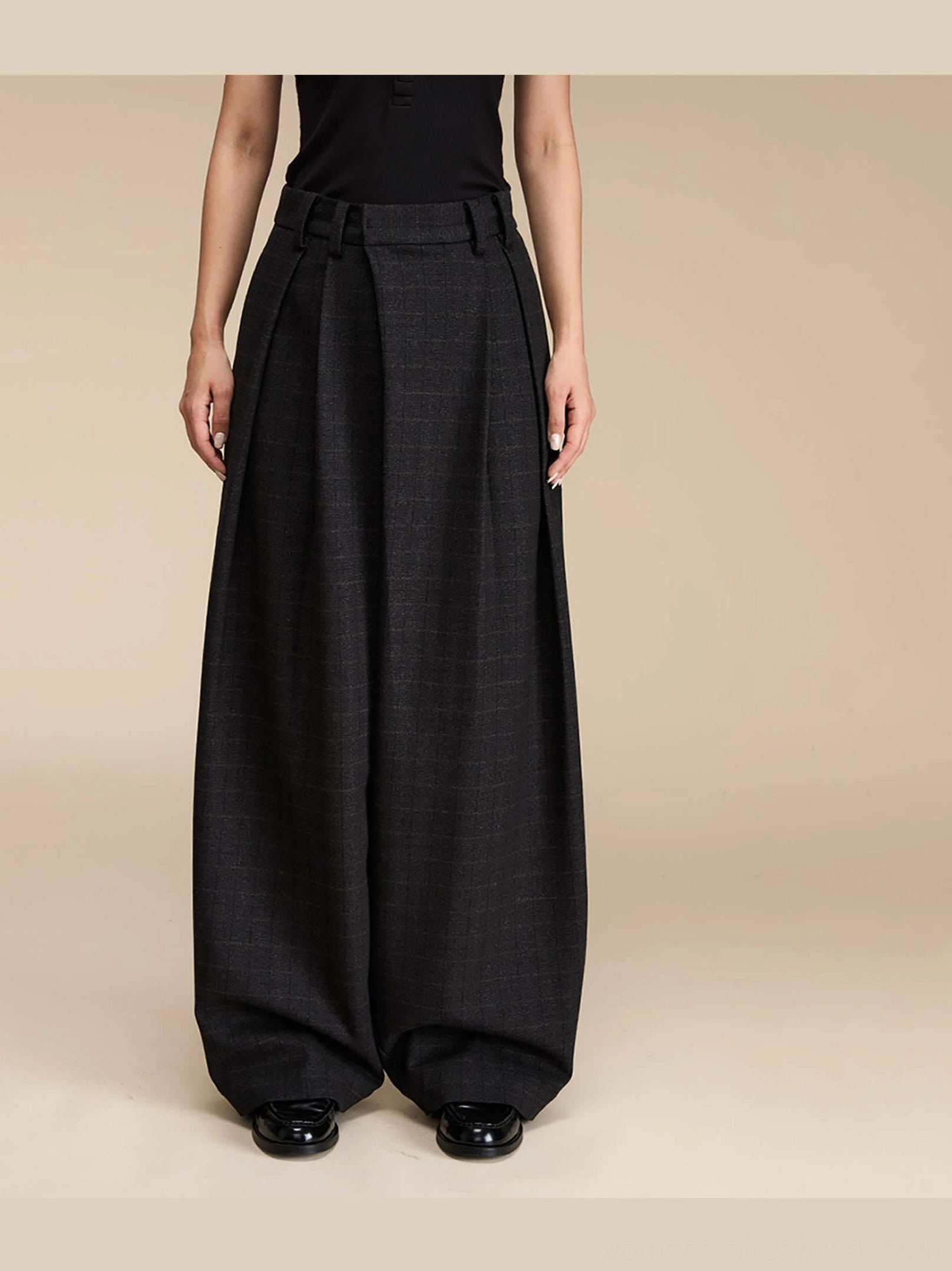 Full front view of dark grey grid plaid high-waisted palazzo pants with belt loops, pleats, and relaxed floor-length wide legs