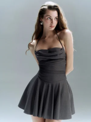 Dark grey halter cowl neck mini dress with ruched waist flared ruffled skirt and tie straps shown in a close front view