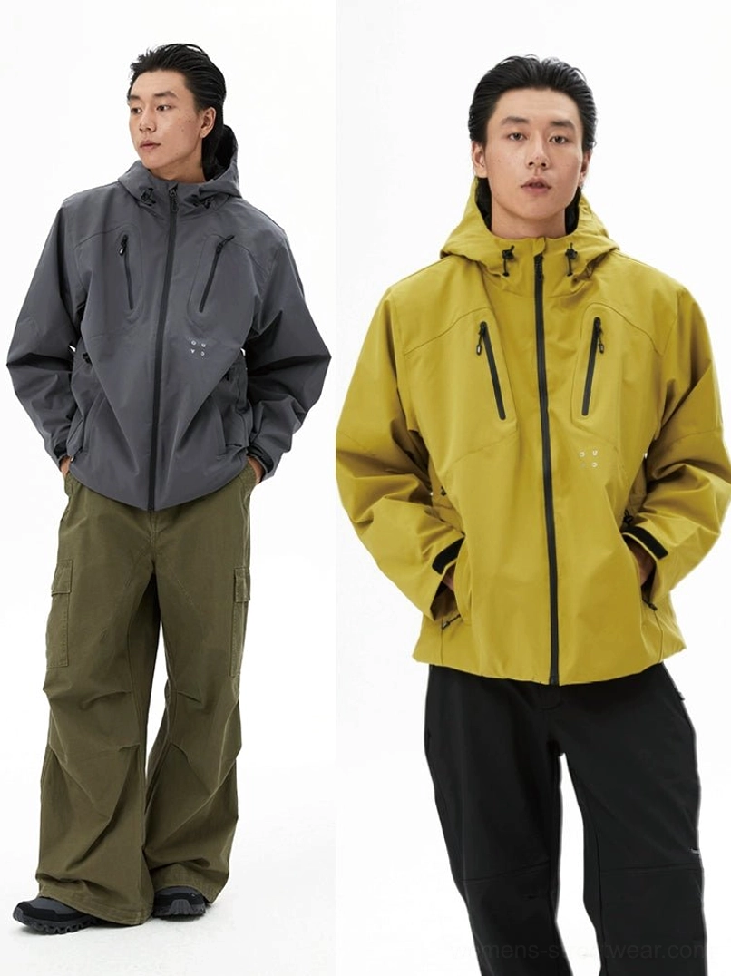 Two models wearing dark grey and mustard yellow outdoor padded jackets with front zippers and functional chest pockets