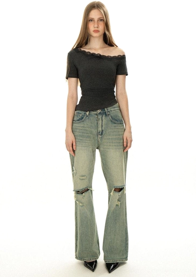 Back view of dark grey off-shoulder lace trim fitted top styled with distressed flared vintage jeans