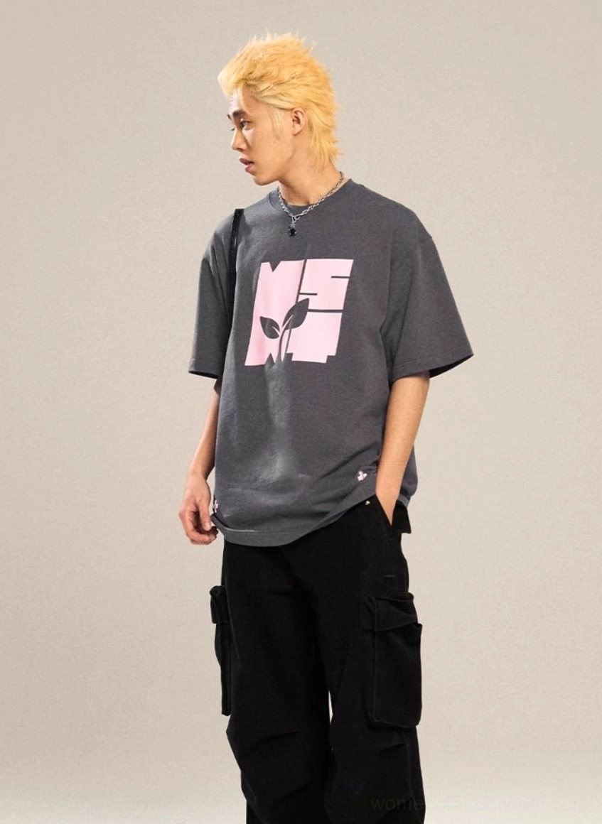 Dark charcoal grey oversized graphic T-shirt with pink square contrast logo, botanical artwork, and relaxed drop-shoulder streetwear fit