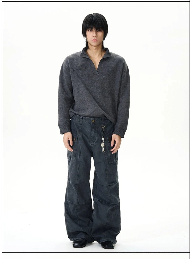 Front view of dark grey panel seam cargo pants with button waist, flap pockets, and straight wide-leg cut