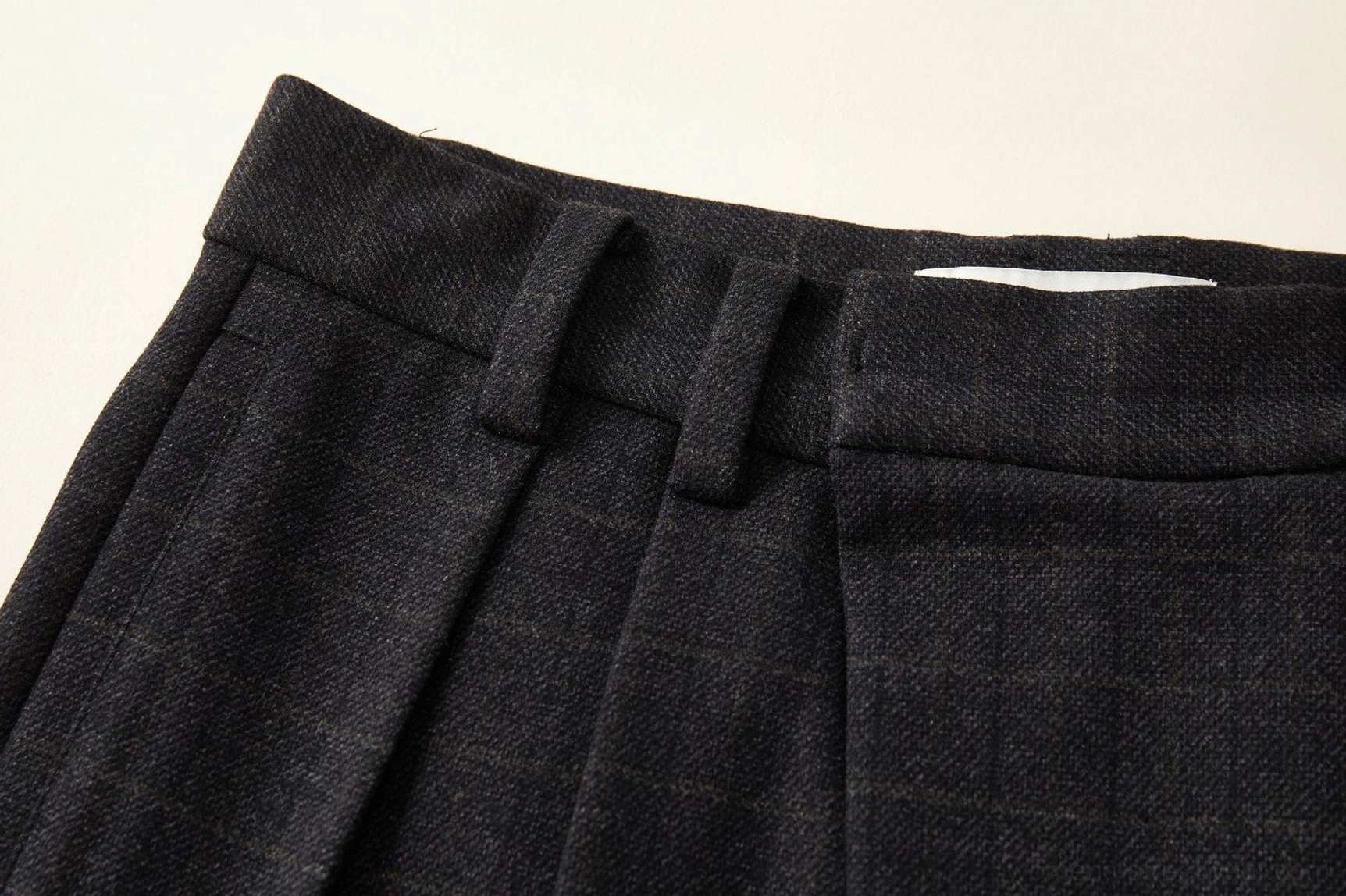 Close-up of the structured waistband and belt loops on dark grey plaid wide-leg streetwear palazzo pants