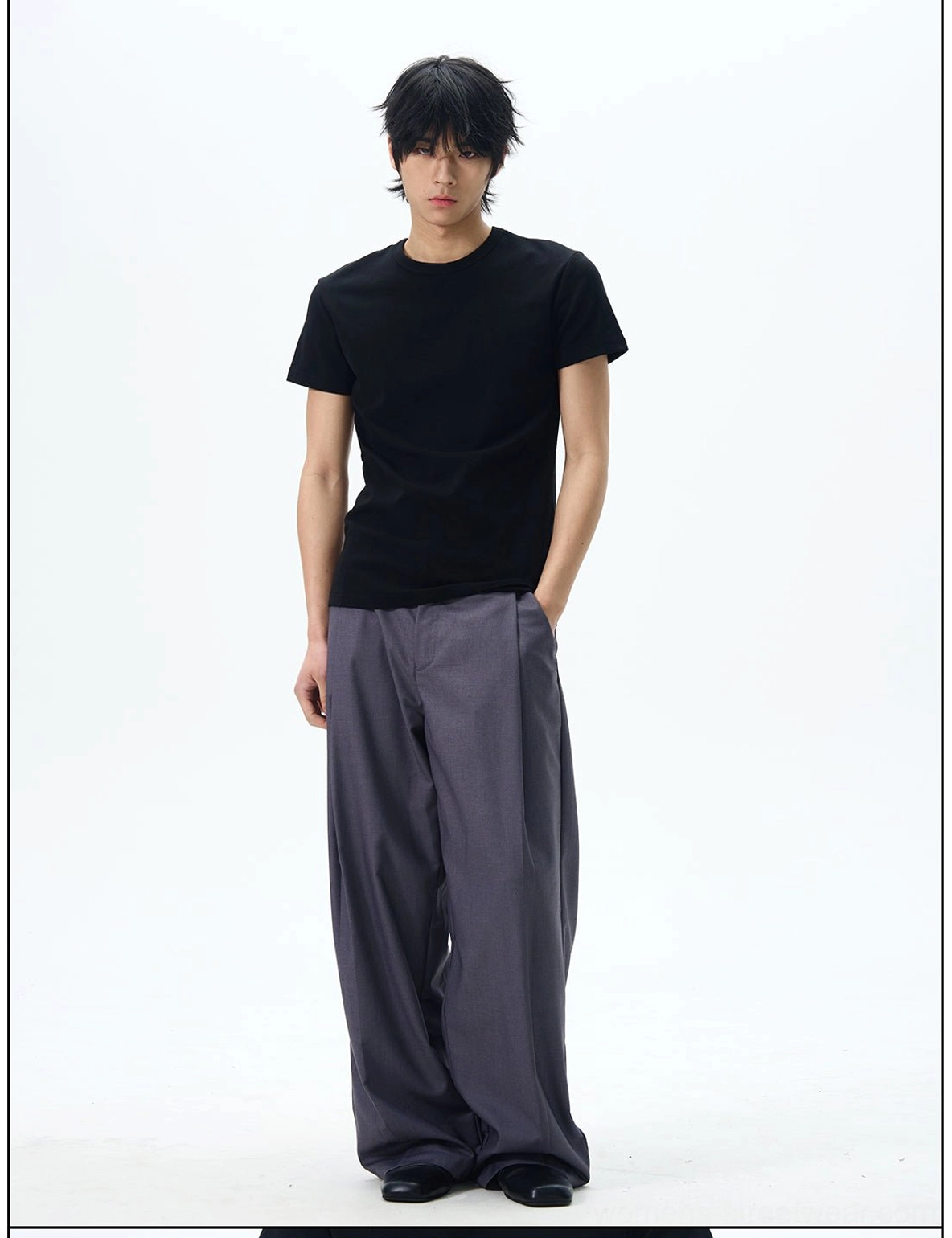 Dark grey relaxed wide-leg dress pants with front pleats and tailored waistband shown in a full-body streetwear outfit