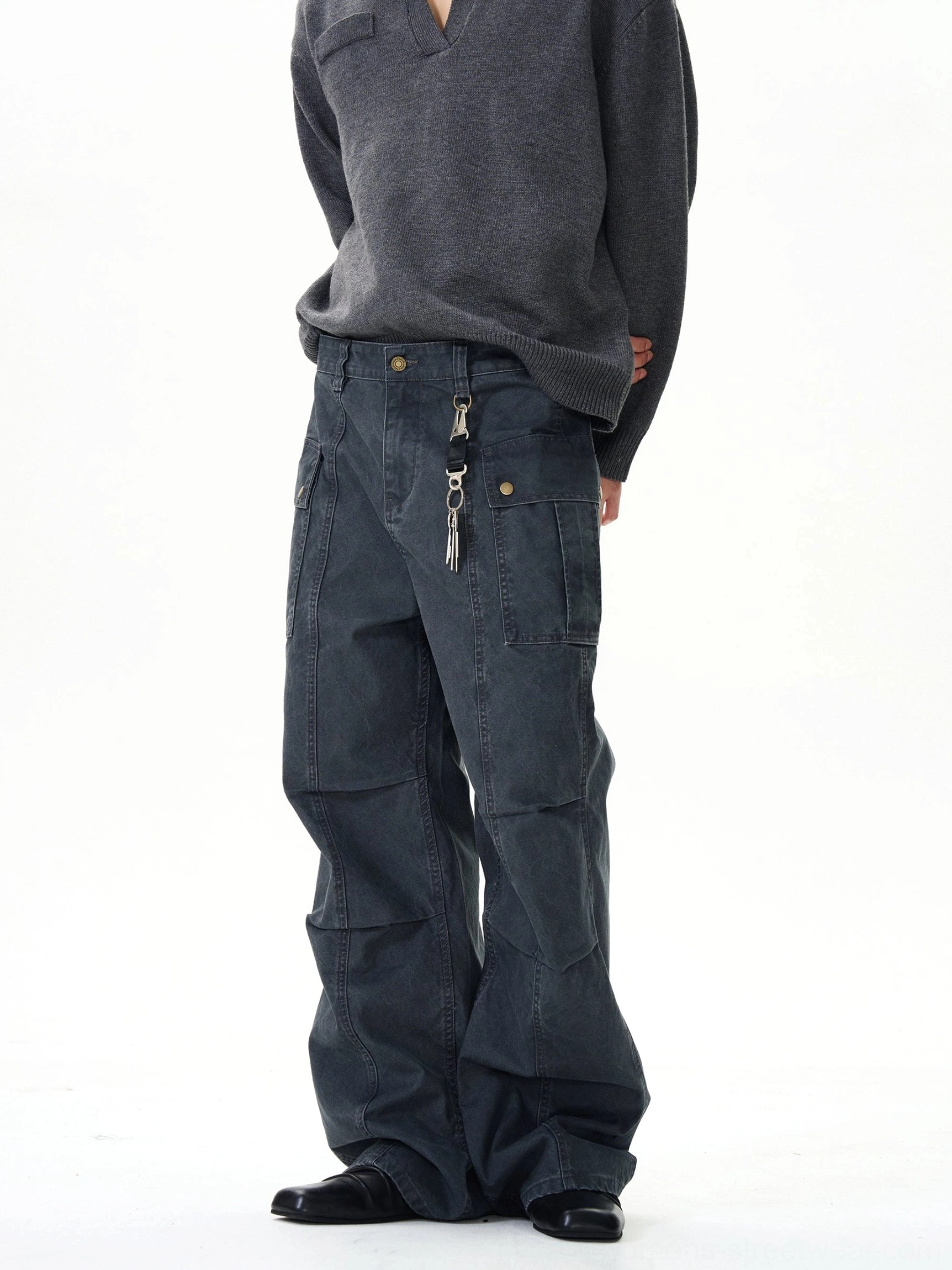 Back view of dark grey wide-leg cargo pants with relaxed baggy fit, side cargo pockets, and metal accessory