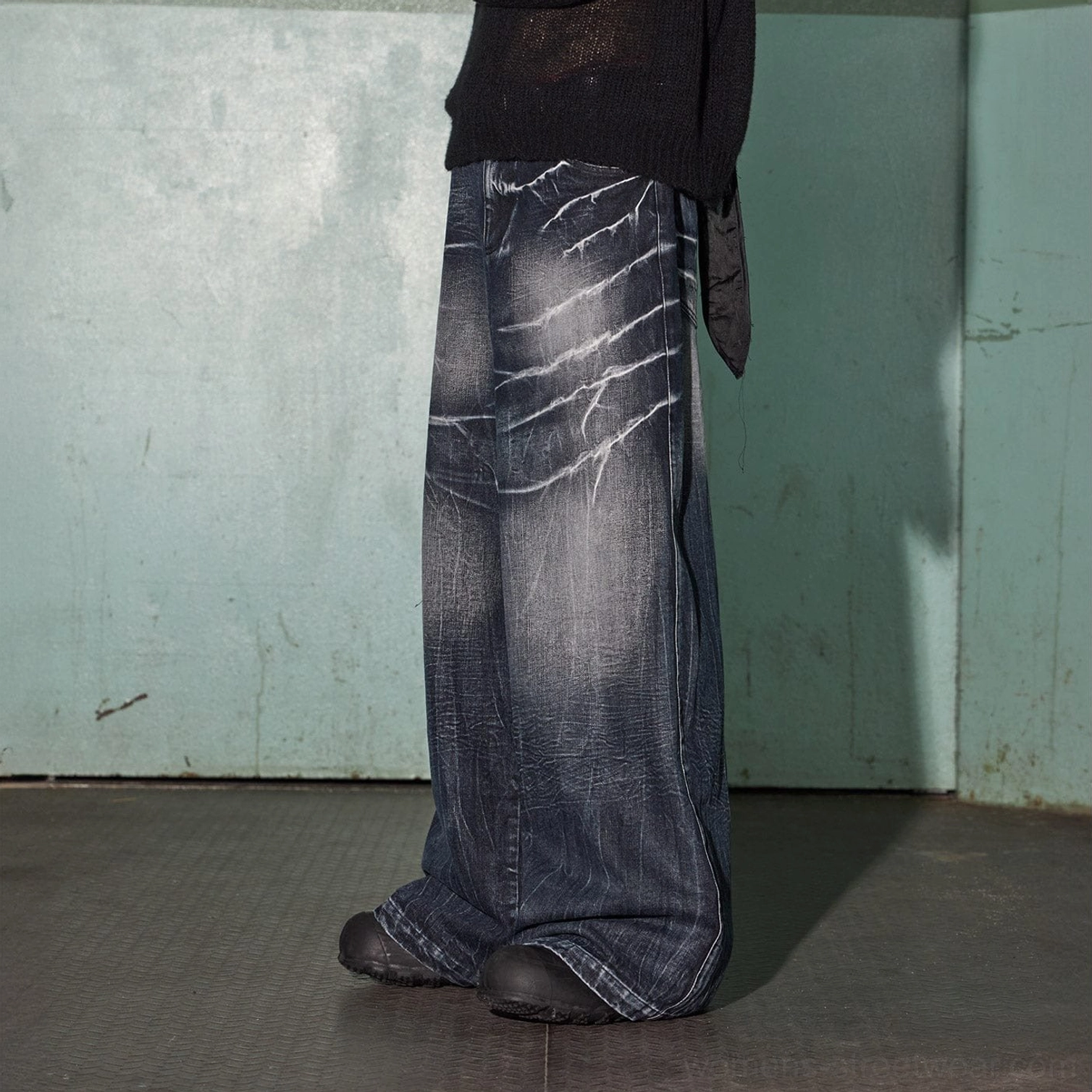 Right side view of full-length dark indigo wide-leg jeans with lightning-style bleached denim texture