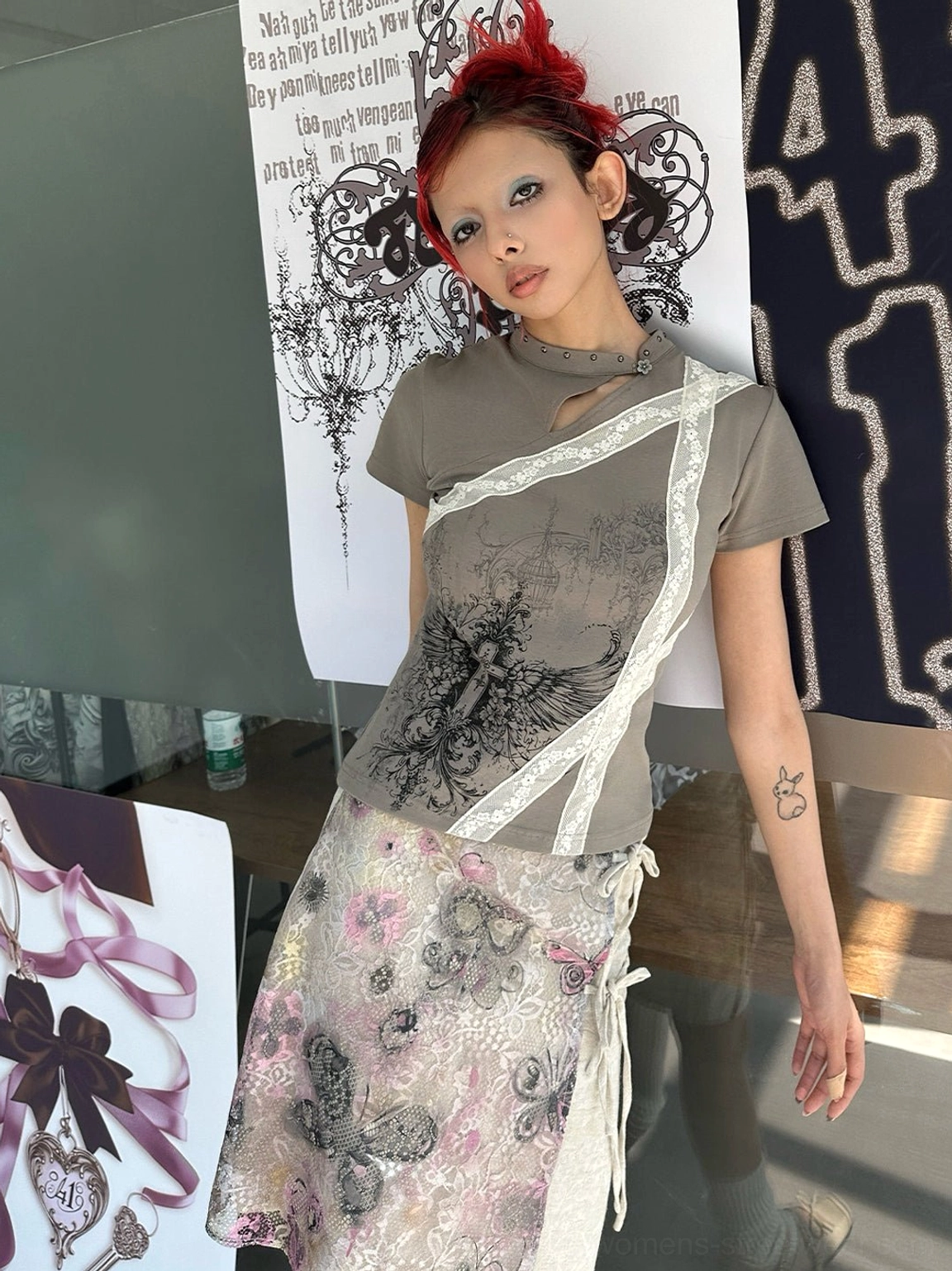 Front view of dark khaki cross wing graphic cheongsam collar slim tee styled with a floral drawstring skirt