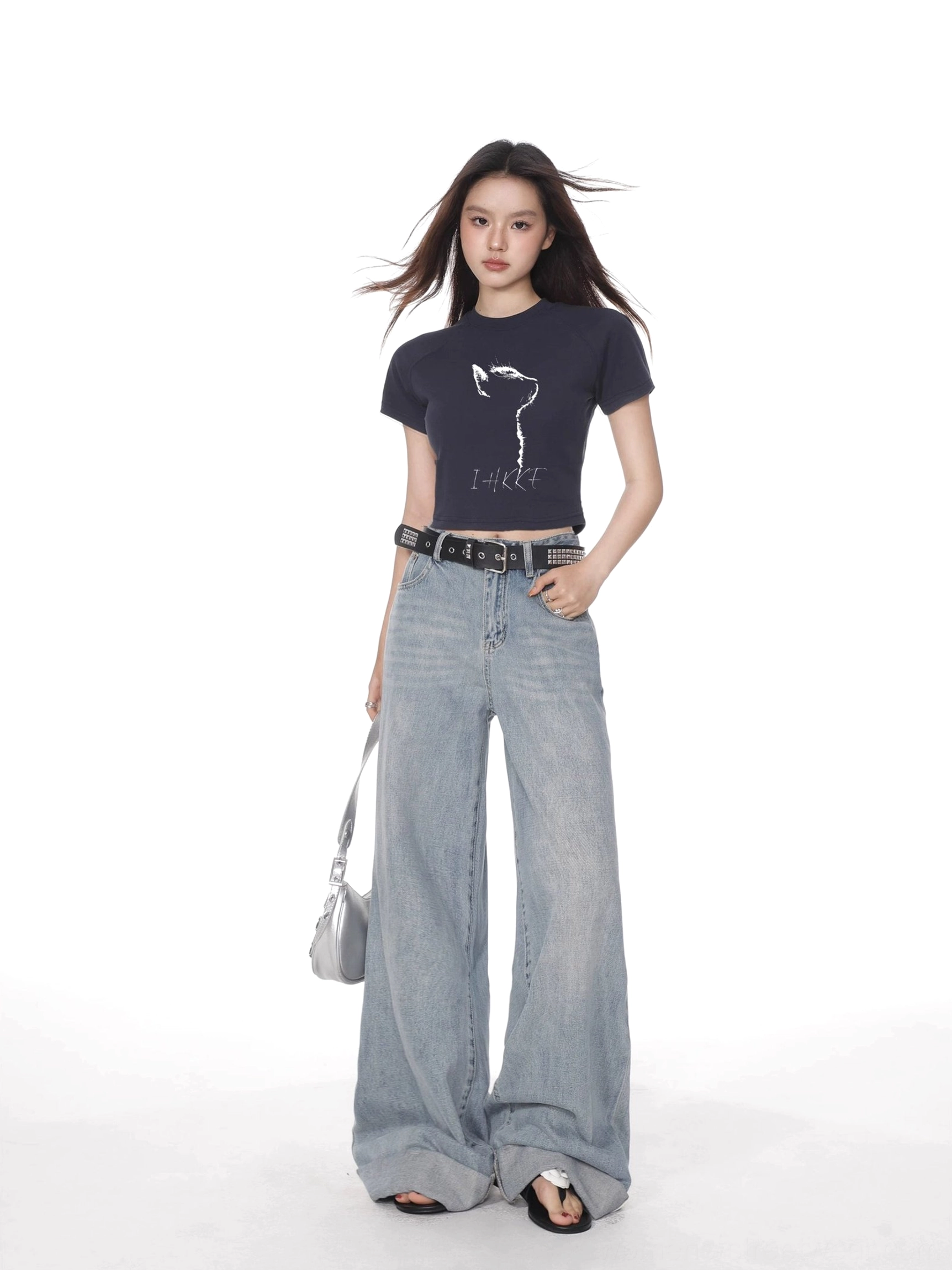 Dark navy cat graphic cropped fitted short sleeve t-shirt styled with light blue wide leg jeans and silver shoulder bag