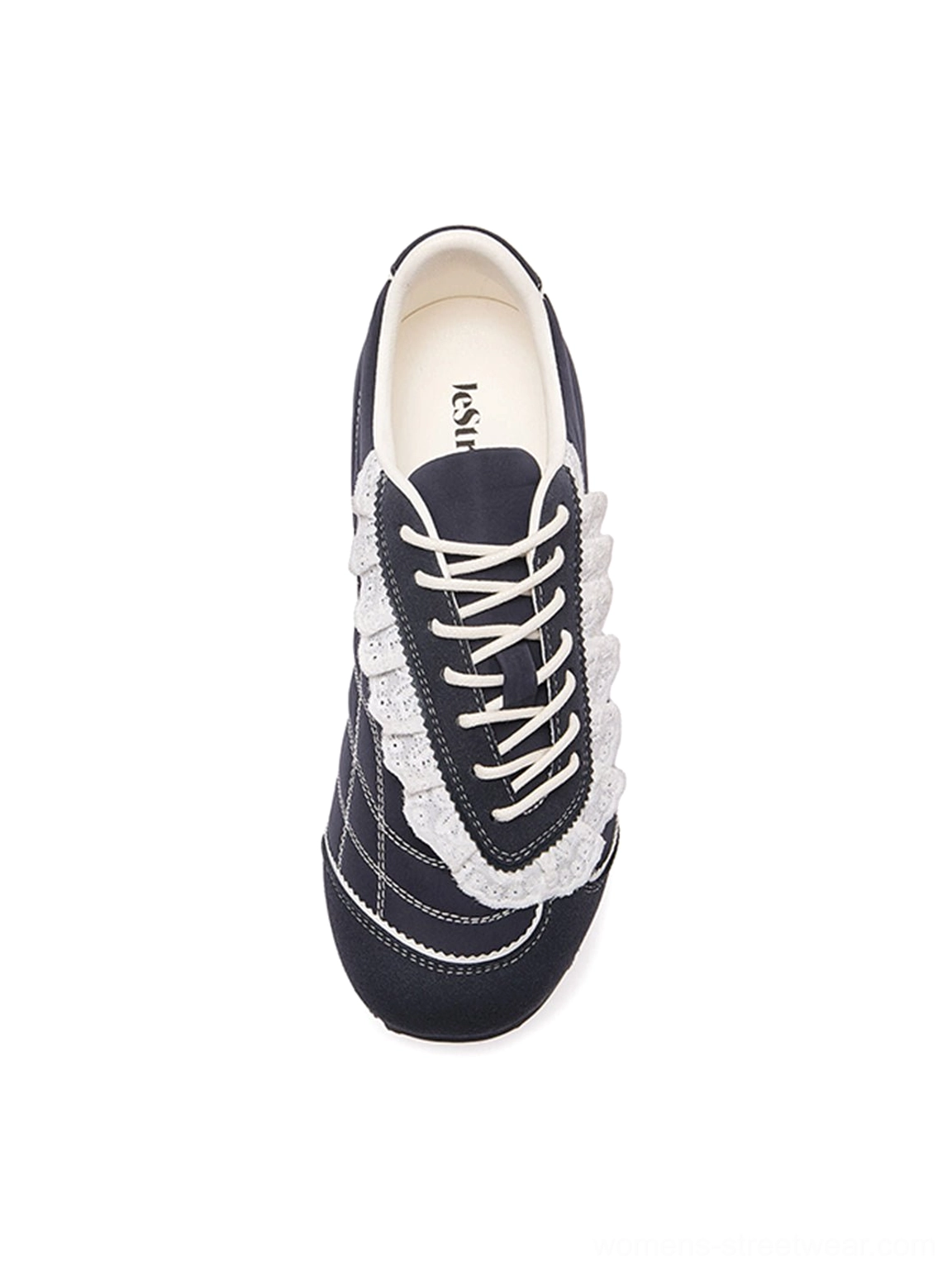 Close top view of dark navy trainer toe and lacing area with white ruffled lace and contrast stitching