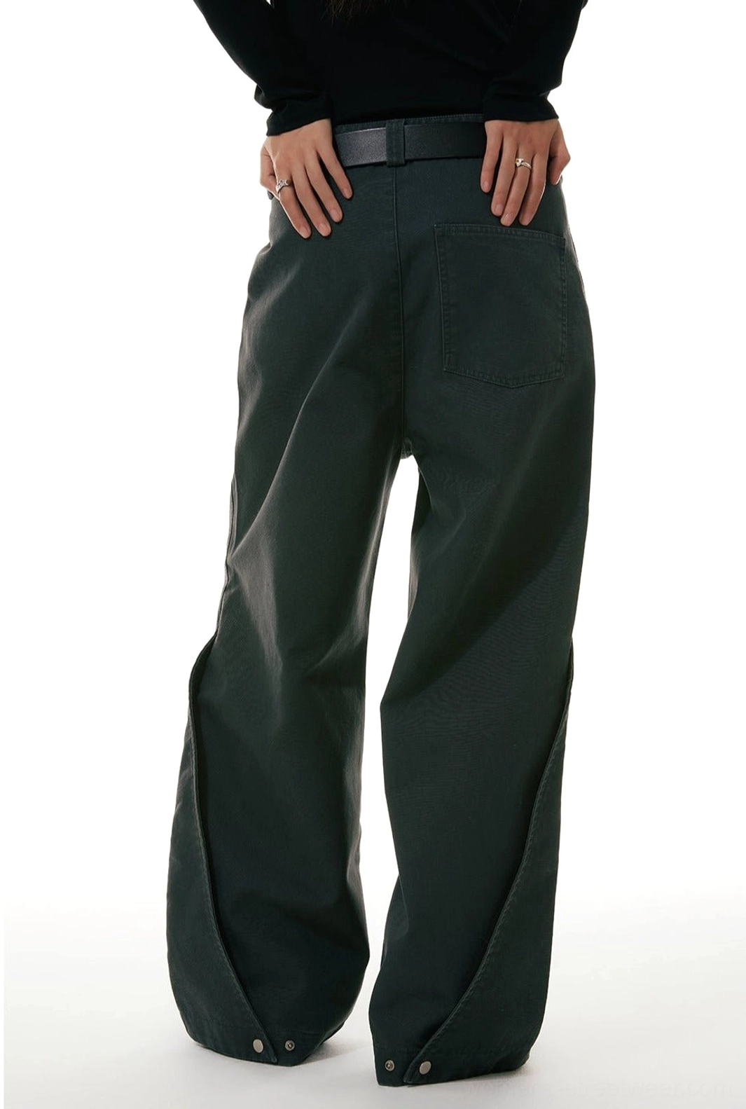 Low-angle back view of dark olive green wide-leg workwear denim jeans with rear patch pockets and adjustable button cuff tabs