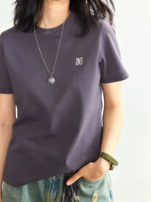 Dark purple minimalist embroidered logo crew neck t-shirt upper body front view ripped denim shorts
