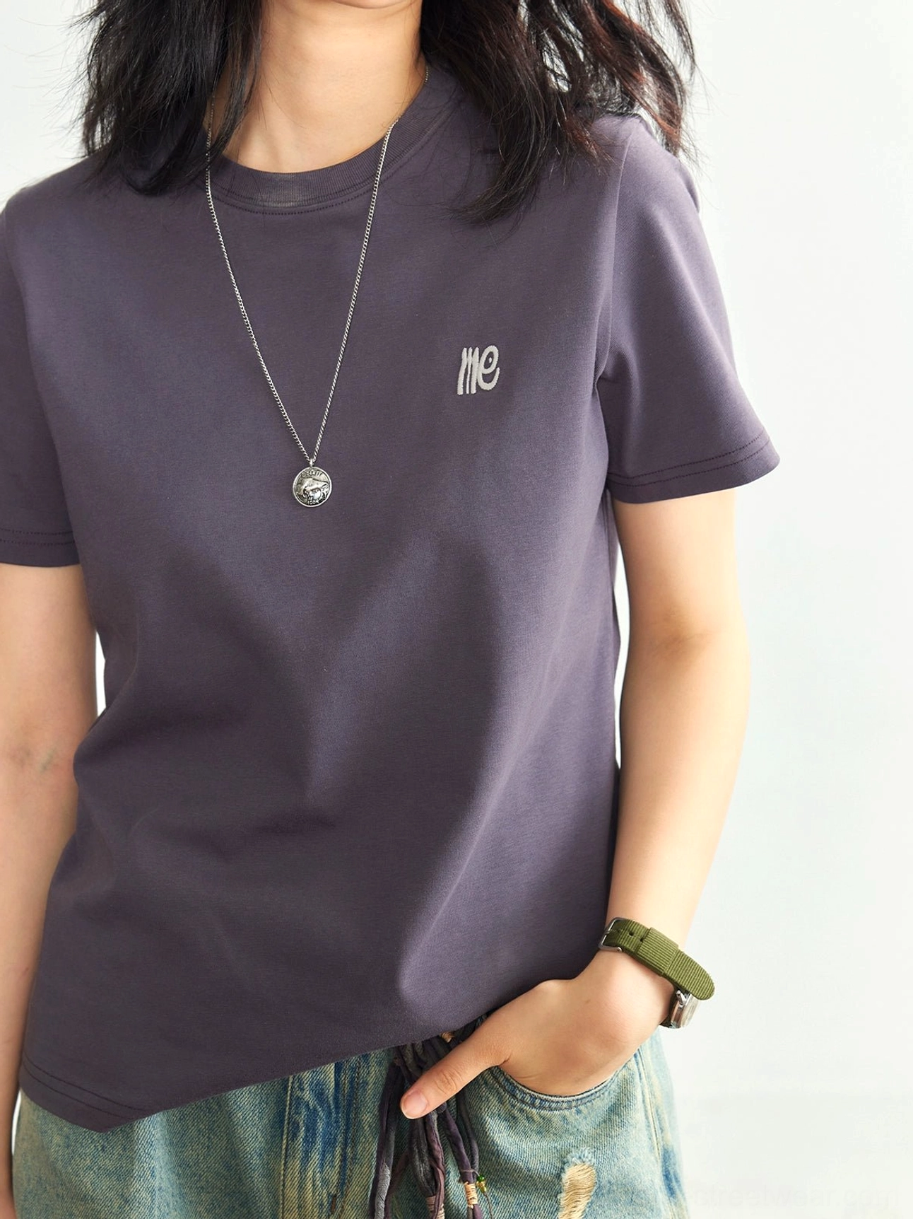 Dark purple minimalist embroidered logo crew neck t-shirt upper body front view ripped denim shorts