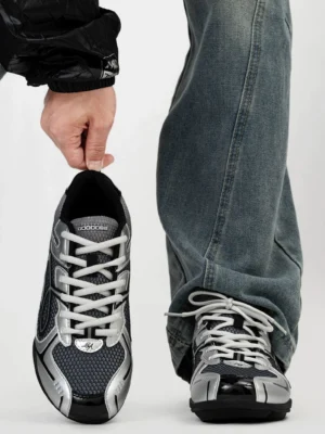 Pair of dark silver futuristic retro runner sneakers viewed from above showing glossy silver toe caps breathable black mesh laces and Y2K streetwear styling