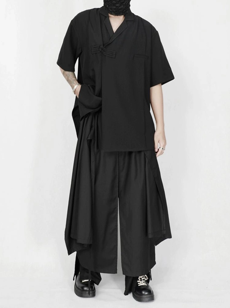Full darkwear outfit featuring asymmetric draped black wide-leg streetwear trousers and black cross-collar top