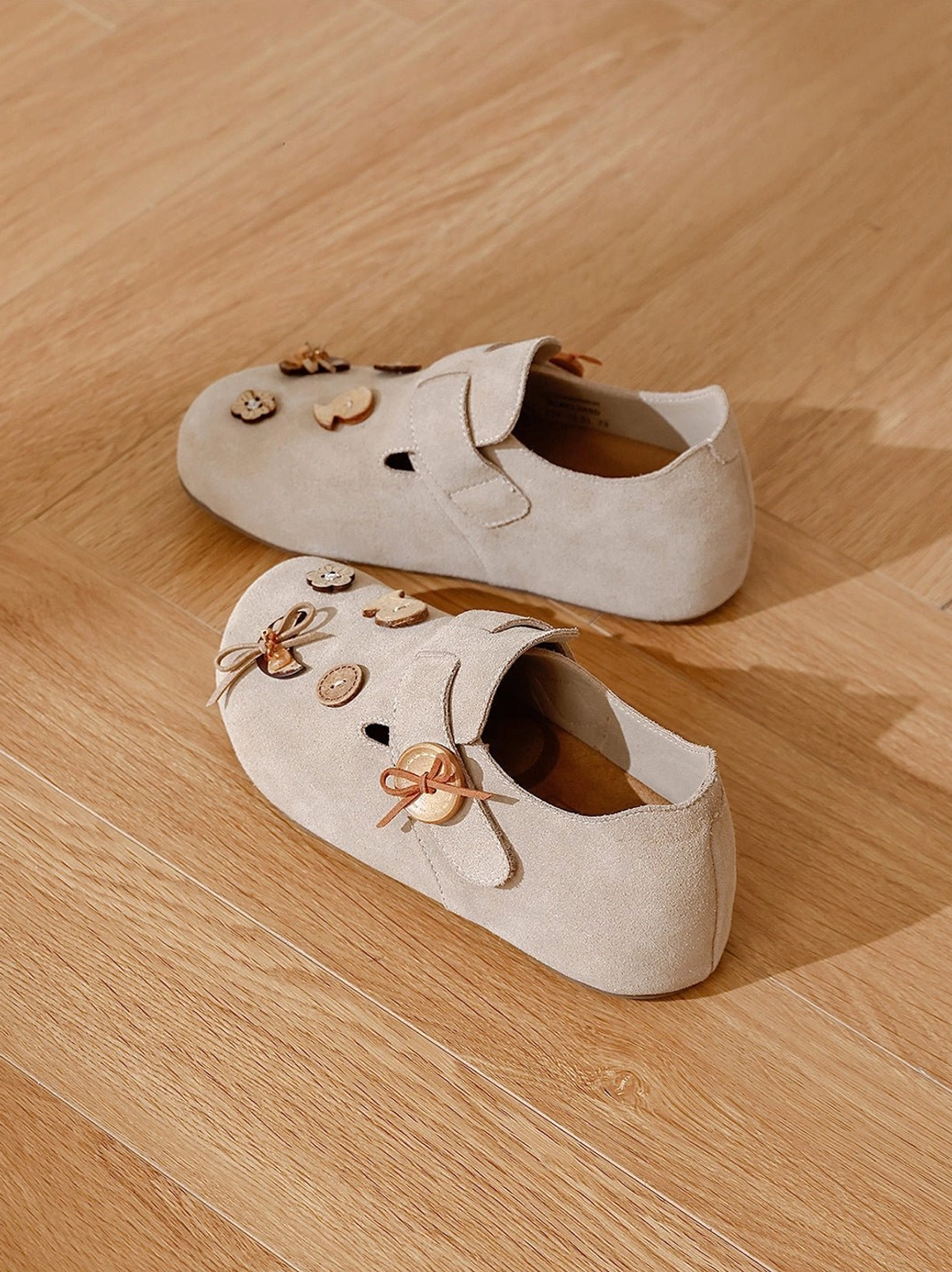 Decorative suede-look slip-on shoes with cute wooden-style buttons and strap fasteners shown from multiple angles