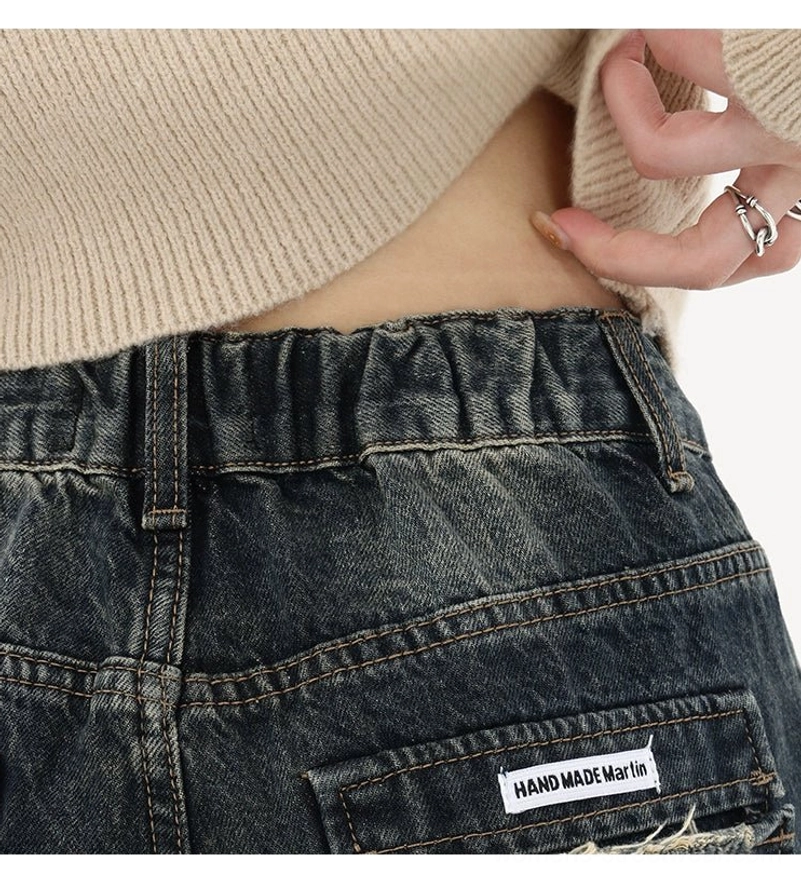 Deep blue wide-leg jeans waistband close-up showing belt loops elastic back waist frayed edge and back pocket detail