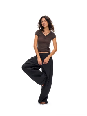 Deep gray draped wide-leg suit pants styled with a brown cropped tee, showing the relaxed streetwear fit, fluid suiting fabric, and full-length leg shape