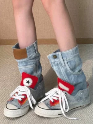 Front on-foot view of women's denim fold-cuff high-top platform sneakers with red star details, white laces, and rubber toe caps