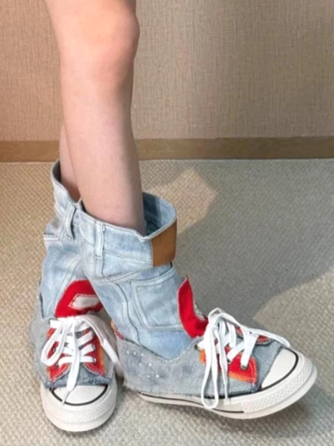 Three-quarter view of women's denim high-top platform sneakers with frayed denim trim, red star panel, and casual streetwear styling
