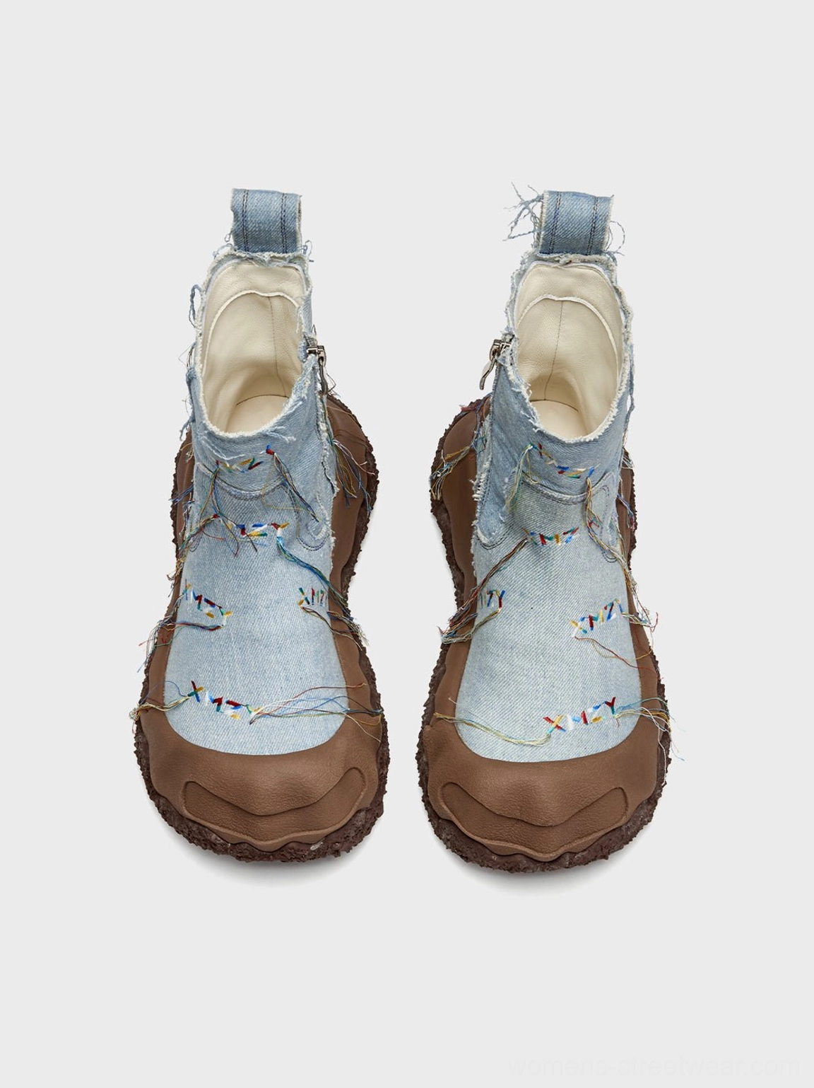 Front view of denim fringe western ankle boots showing brown toe caps, boot lining, and embroidered vamp details