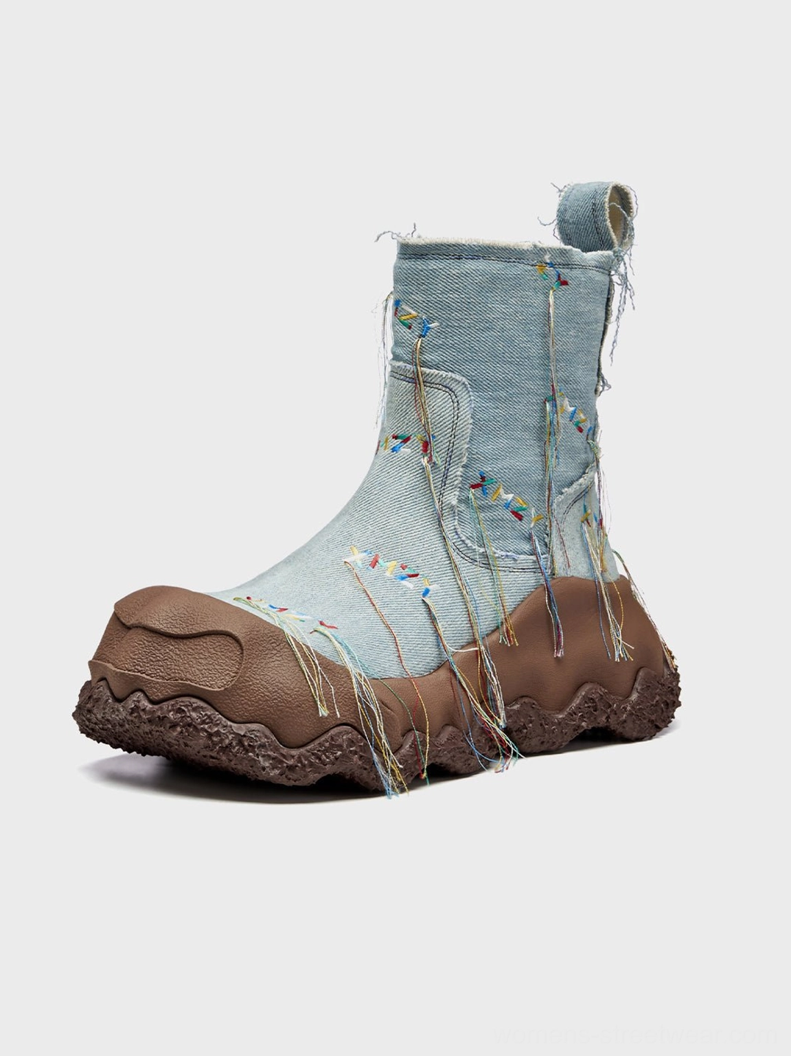 Right front three-quarter view of denim fringe western ankle boots with colorful geometric vamp embroidery