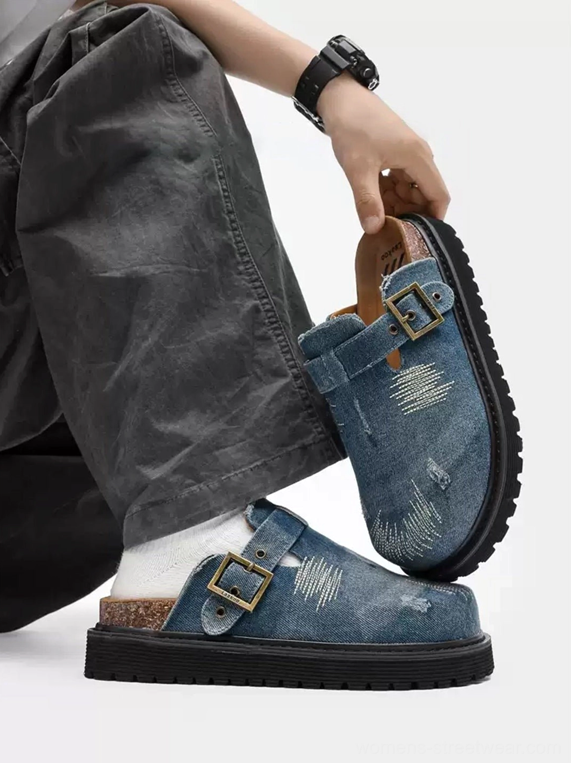 Close wearing view of denim platform mule clogs with visible cork insole, adjustable buckle strap, white crew socks, and anti slip sole
