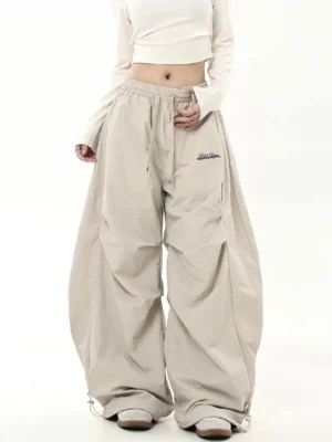 Light khaki desert drift oversized parachute pants with drawstring waist and adjustable bungee hems front view