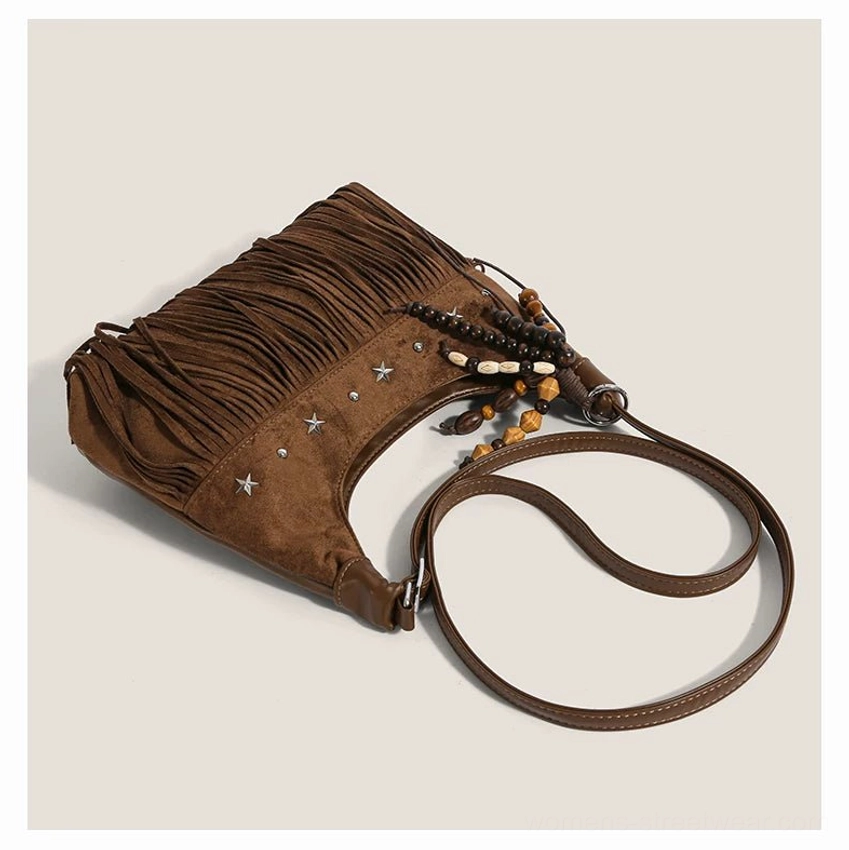 Brown faux suede star stud fringe hobo bag laid flat with long tassels beaded pendant and shoulder strap