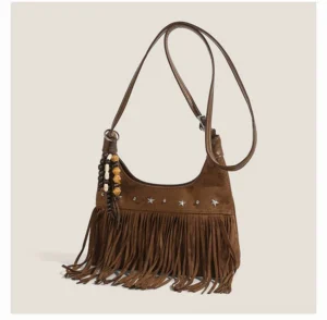 Brown fringe faux suede hobo bag with silver star rivets beaded charm and shoulder strap hardware angled view