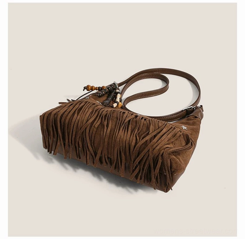 Brown fringe faux suede hobo shoulder bag laid flat showing full tassel trim beaded charm and star studs