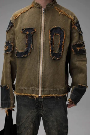 Front view of an army green distressed applique denim jacket with JO frayed patches, black stand collar, zipper closure, and oversized streetwear fit