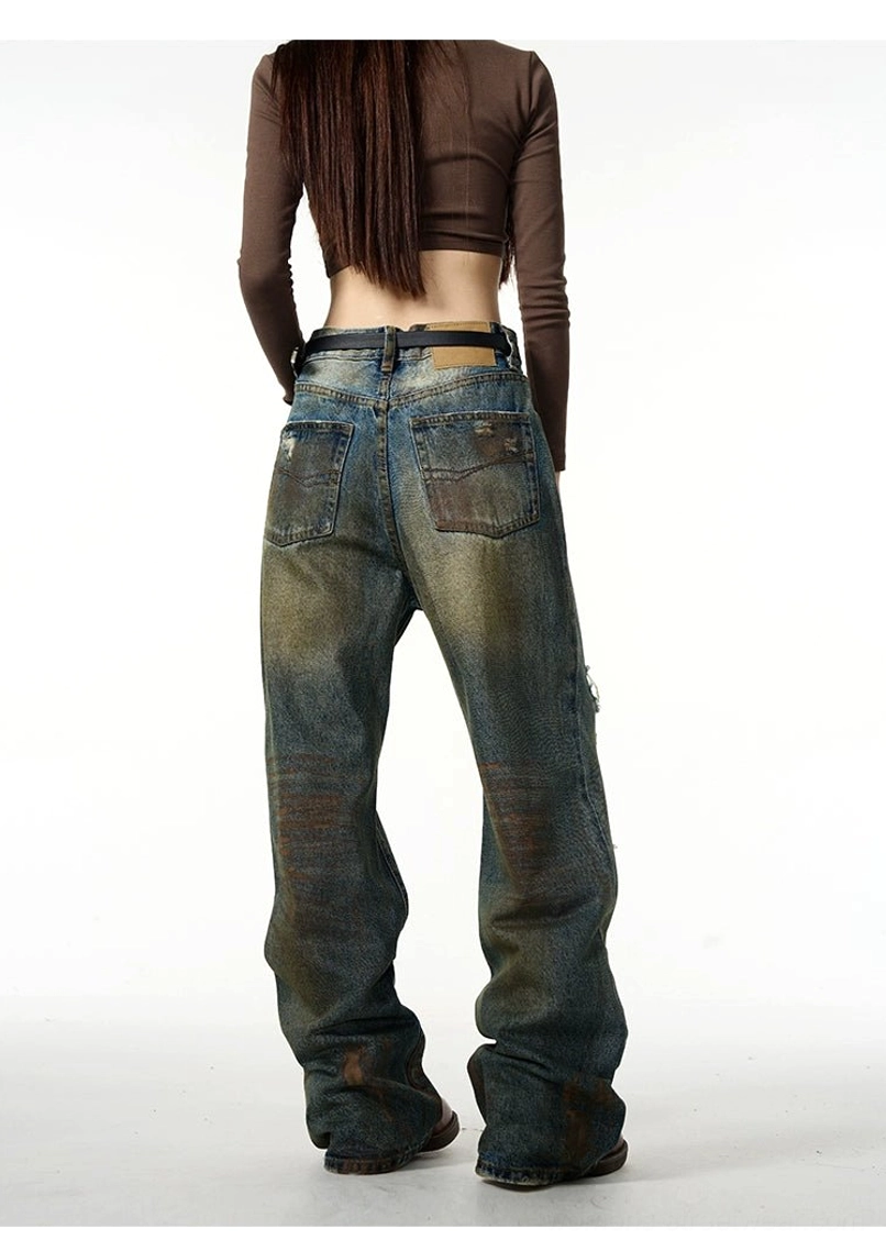 Distressed baggy ripped jeans in vintage blue denim with oversized Y2K streetwear silhouette and wide-leg styling