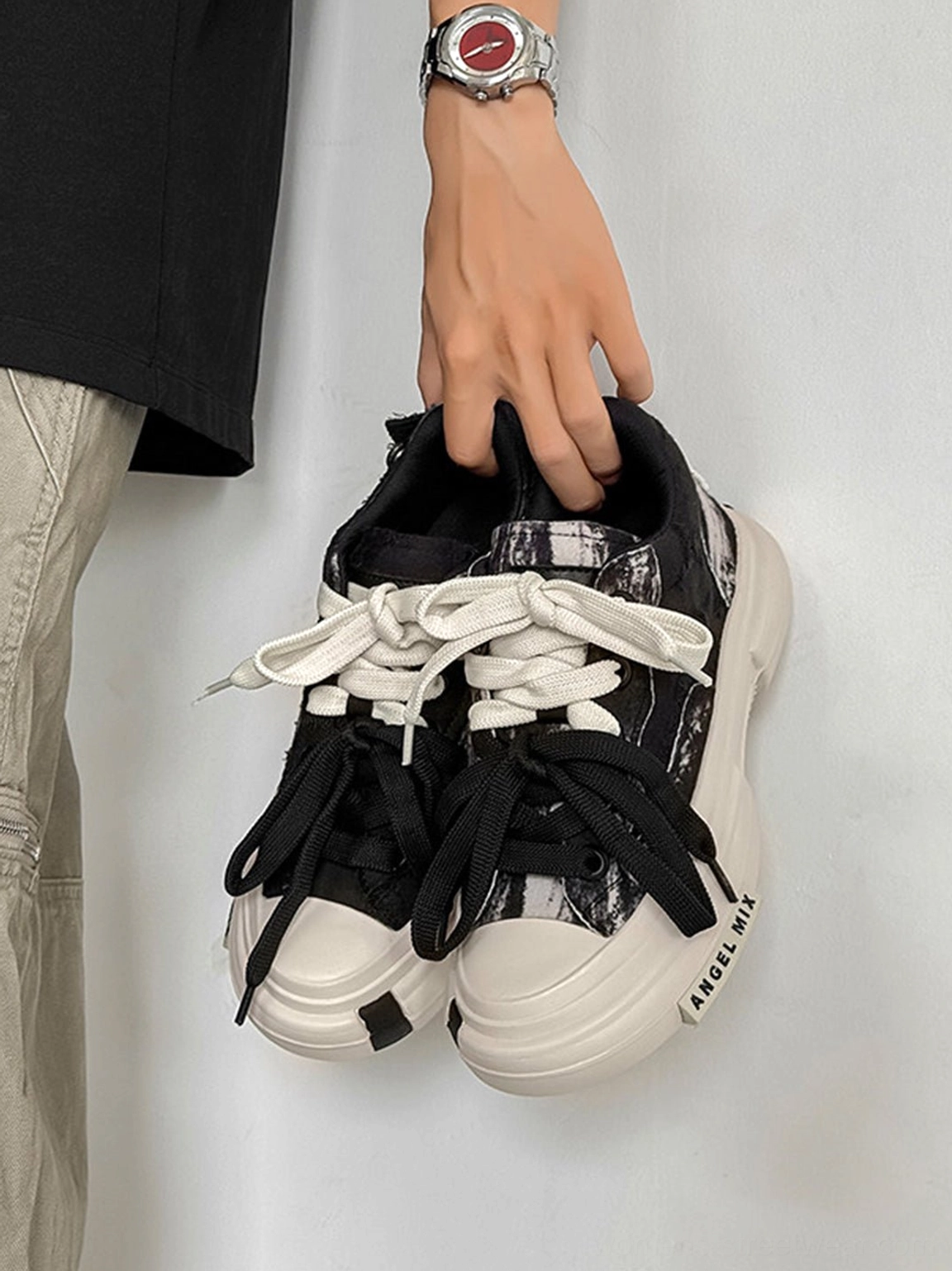 Close up top view of distressed black canvas platform sneakers showing textured fabric, white sole, and streetwear details