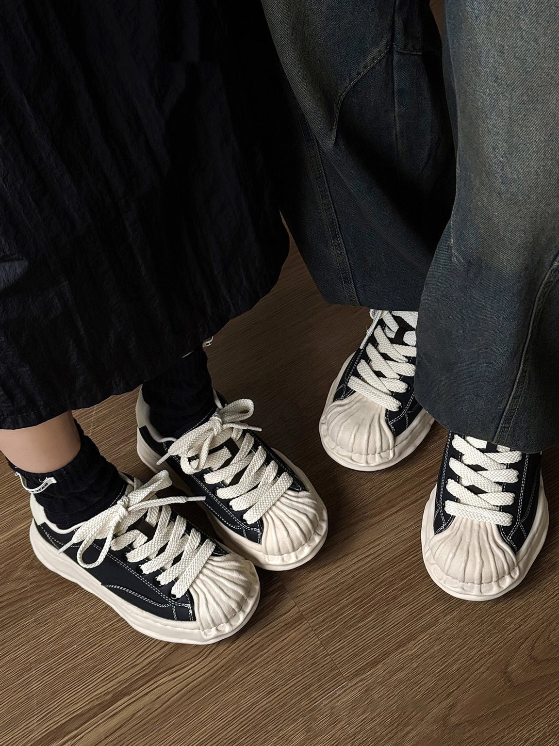 Distressed black and cream height-boosting sneakers with sculpted platform sole for modern unisex streetwear styling