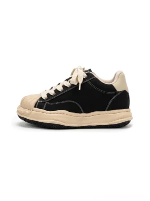 Black distressed platform court sneakers with cream shell toe, frayed contrast panels, and thick 7cm height-boosting sole shown from the left side