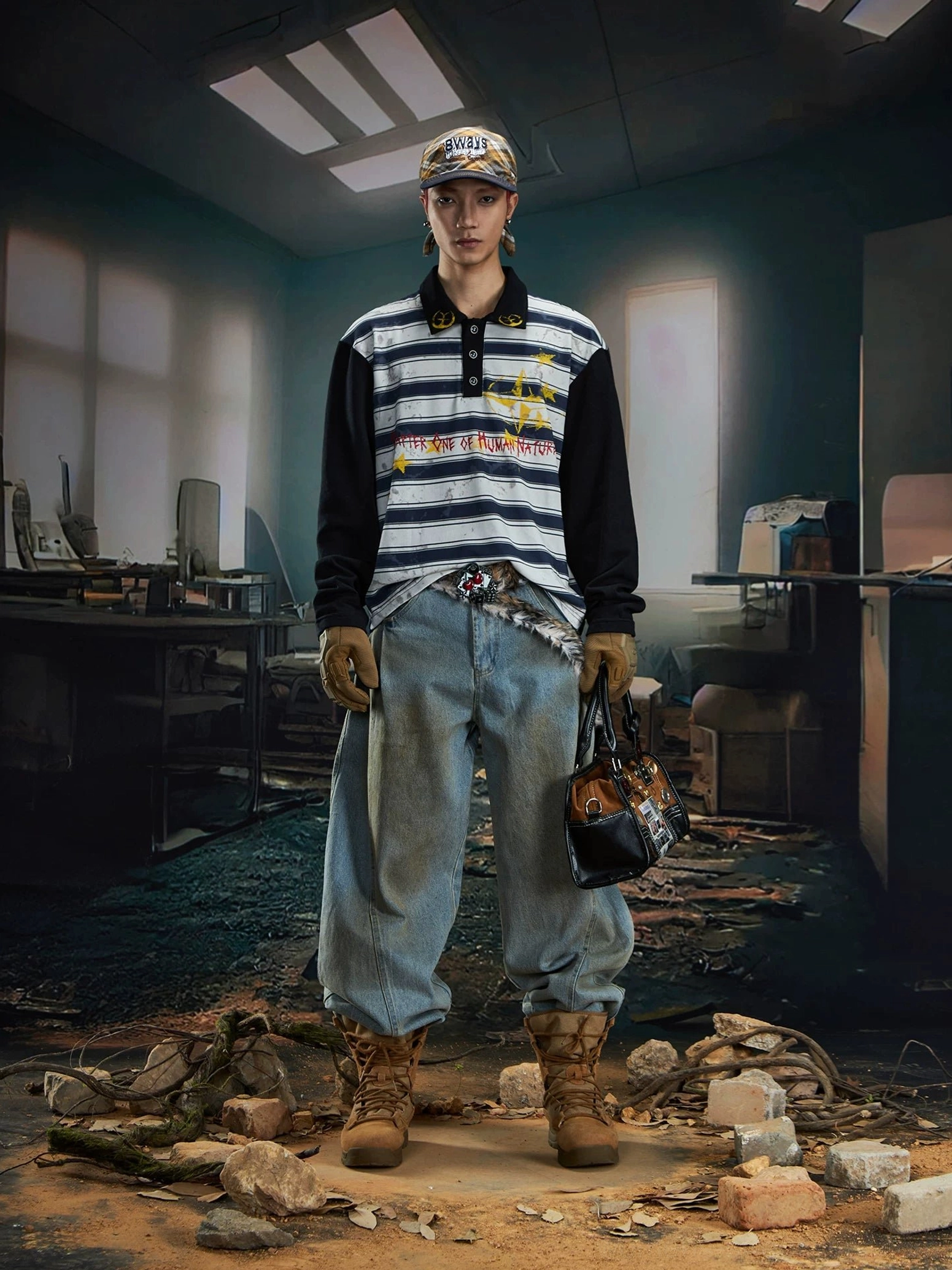 Male model wearing a distressed blue grey striped rugby polo shirt with light wash baggy jeans, work boots, and leopard print tote