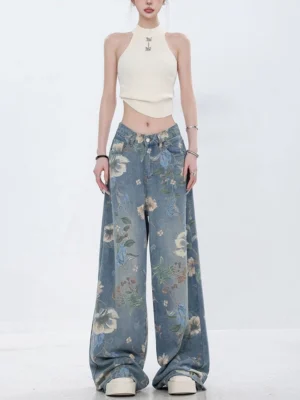 Women's distressed floral wide-leg jeans shown from the front with floor-length relaxed legs and all-over botanical print