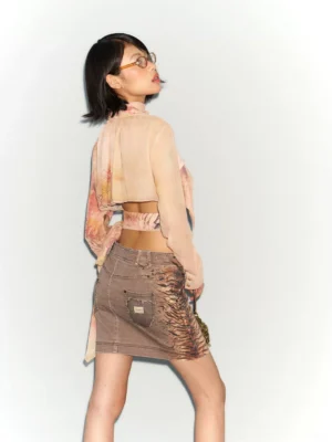 Back view of distressed brown sheer floral scarf blouse and denim mini skirt set showing cropped back and patch pocket
