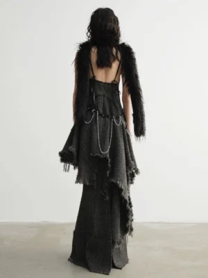 Back view of distressed charcoal tweed mermaid maxi skirt styled with layered accessories in a minimalist studio