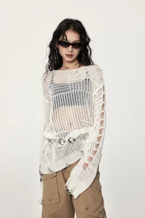 Three-quarter view of a loose off-white crochet streetwear sweater with distressed sleeve slits, open knit panels, and industrial metal waist accents