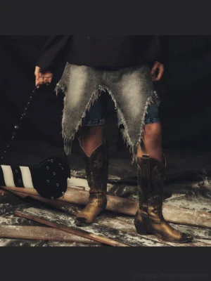 Distressed layered denim chaps shorts in faded grey wash with jagged fringe hem styled with cowboy boots