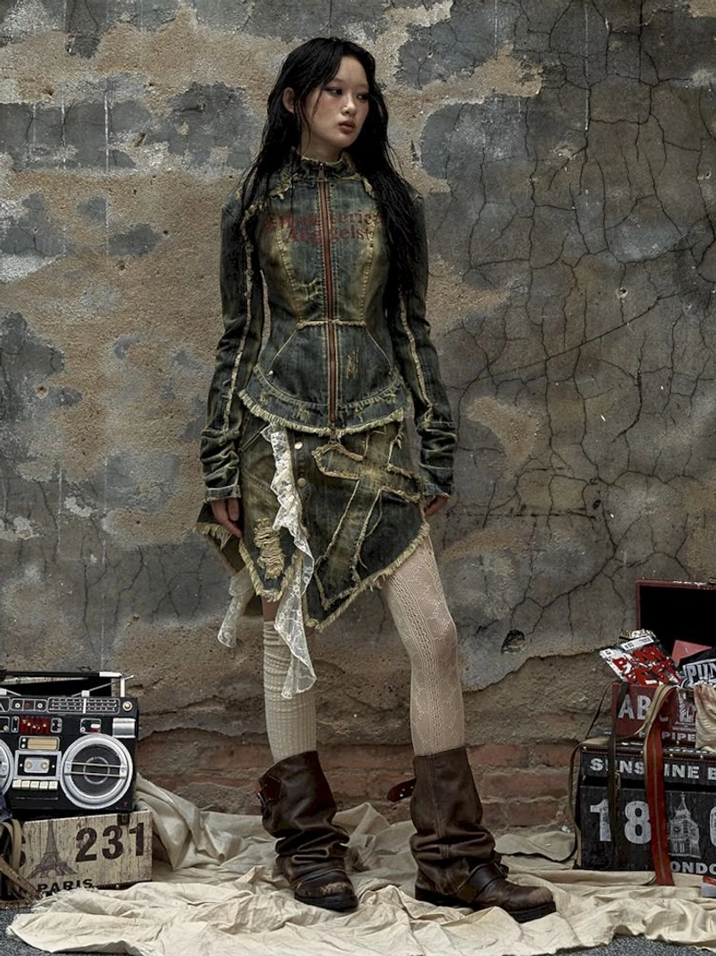 Distressed denim corset jacket and asymmetric mini skirt outfit with worn denim texture and frayed hem details