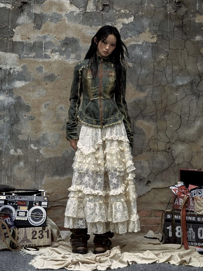 Full front view of distressed denim corset jacket styled with layered ruffle lace skirt in vintage streetwear outfit