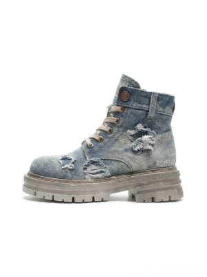 Side profile of star detail distressed denim platform combat boots with frayed ripped blue denim upper and chunky lug sole