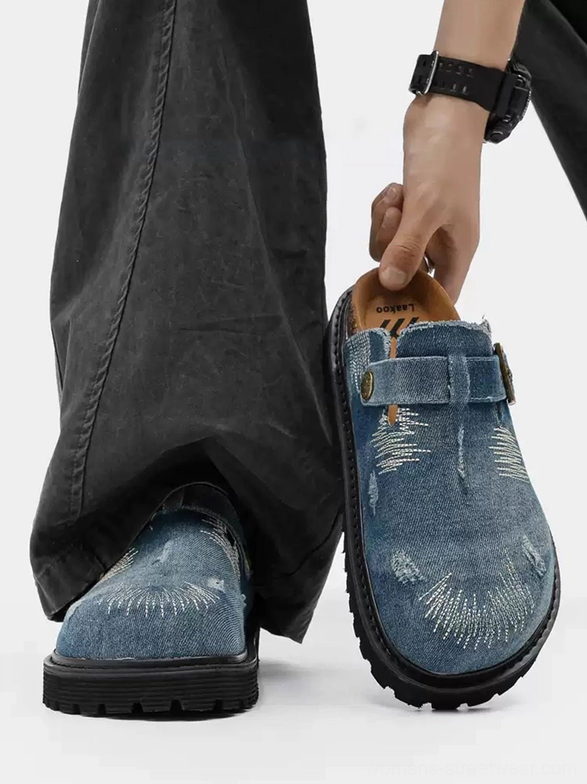 Streetwear model wearing distressed denim platform mule clogs with dark gray cargo pants in a first person on foot view