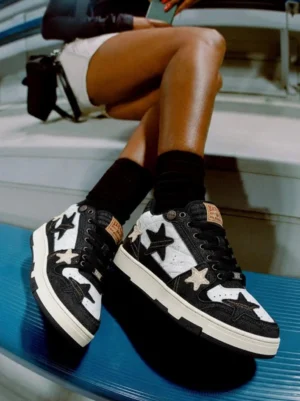 Girl wearing distressed denim star low-top sneakers on white bench skate surface top-down view street style